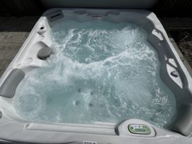A hot tub with bubbling water and control panel at Riviere House Hayle