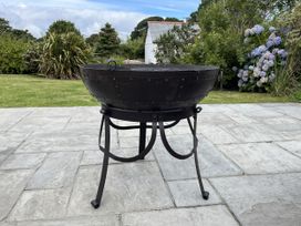 A fire pit on a stone patio at Riviere House in Hayle
