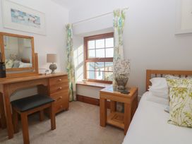 A bedroom with a bed and a desk with mirror at Riviere House in Hayle