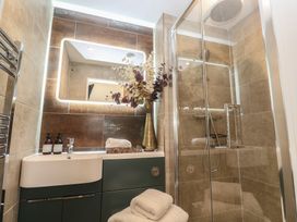 A bathroom with a sink, shower, and decorative vase at Riviere House in Hayle