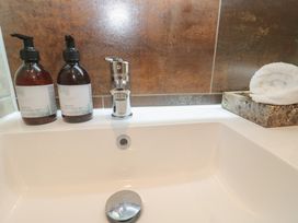 A wash basin with lotion and wash bottles at Riviere House in Hayle