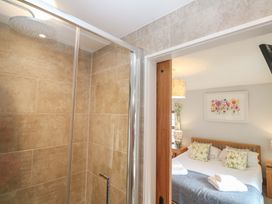 A bathroom with a shower and a bed visible at Riviere House in Hayle