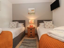 A bedroom with two beds and a bedside table at Riviere House Hayle