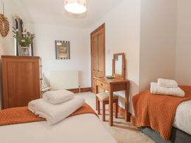 A bedroom with beds, a desk and a mirror at Riviere House in Hayle