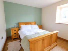 A bedroom with a bed and nightstands at Y Stabal near Llanilar