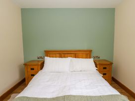 A bedroom with a bed and bedside tables at Y Stabal near Llanilar