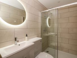 A bathroom with a sink, shower, and mirror at Y Stabal near Llanilar