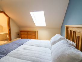 A bedroom with a bed and dresser at Y Stabal near Llanilar