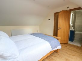 A bedroom with a bed and an en-suite bathroom at Y Stabal near Llanilar