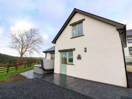 An outdoor view of a house with a patio and hot tub at Y Stabal near Llanilar