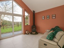 A snug with a wood stove and large windows at Y Stabal near Llanilar