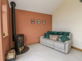 A living room with a sofa and a wood stove at Y Stabal near Llanilar
