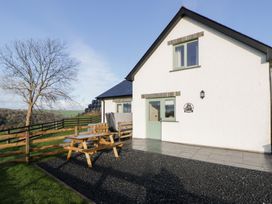 A house exterior with a table and benches at Y Stabal near Llanilar