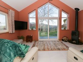 A living room with a sofa and fireplace at Y Stabal near Llanilar