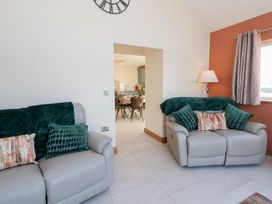 A living room with sofas and a doorway leading to the dining area at Y Stabal near Llanilar