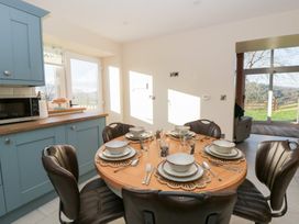 A kitchen with a dining table set for six at Y Stabal near Llanilar