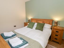 A bedroom with a bed and nightstands at Y Stabal near Llanilar