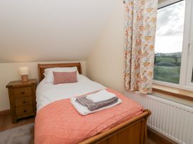 A bedroom with a bed and nightstand at Y Stabal near Llanilar