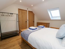 A bedroom with a bed, shelf, and wardrobe at Y Stabal near Llanilar