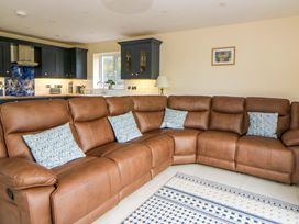 A living room with a sofa and kitchen visible at Y Beudy near Llanilar