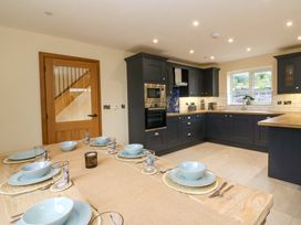 A kitchen with dining table and dishes at Y Beudy near Llanilar