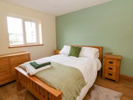 A bedroom with a bed and furniture at Y Beudy near Llanilar
