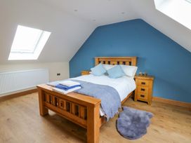 A bedroom with a bed and bedside table at Y Beudy near Llanilar