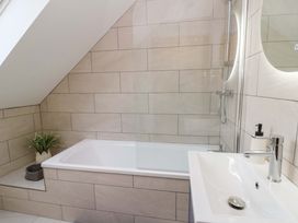 A bathroom with a bath tub and sink at Y Beudy near Llanilar
