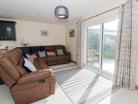 A living room with a sofa and sliding door at Beudy near Llanilar