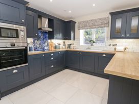A kitchen with cabinets and appliances at Beudy near Llanilar
