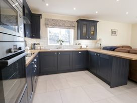 A kitchen with cabinets and a counter near a window at Beudy near Llanilar