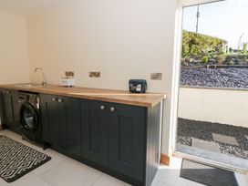 A utility room with a washing machine and sink at Beudy near Llanilar