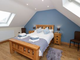 A bedroom with a wooden bed and bedside tables at Beudy near Llanilar