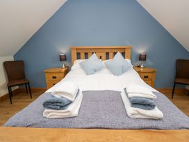 A bedroom with a bed and nightstands at Beudy near Llanilar