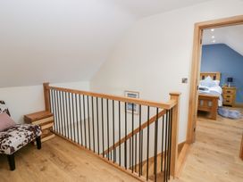 A hallway with a staircase and access to a bedroom at Beudy near Llanilar