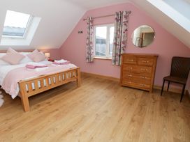 A bedroom with a bed and dresser at Beudy near Llanilar