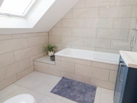 A bathroom with a bathtub and sink at Beudy near Llanilar