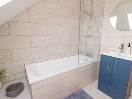 A bathroom with a bathtub and vanity at Beudy near Llanilar
