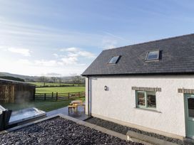 An outdoor area with a hot tub and seating at Beudy near Llanilar