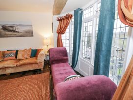 A living room with sofas curtains and a lamp by the window at Riverside Manor in Evesham