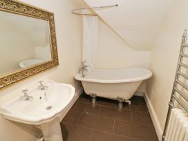 A bathroom with a pedestal sink mirror clawfoot bathtub and heated towel rack at Riverside Manor in Evesham