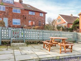 A garden with a picnic table and fenced area at Whitby View in Whitby