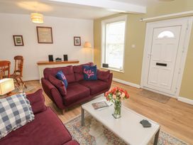 A living room with a sofa and a table at 1 Eden Cottages in Corby Hill
