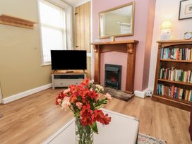 A living room with a television and a fireplace at 1 Eden Cottages in Corby Hill