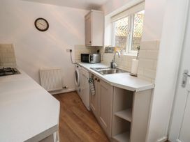 A kitchen with appliances and a window at 1 Eden Cottages in Corby Hill