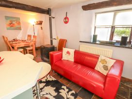 A dining room with a red sofa and dining table at Beck Edge in Braithwaite