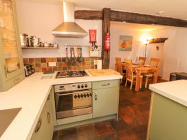 A kitchen with stove and dining table at Beck Edge in Braithwaite