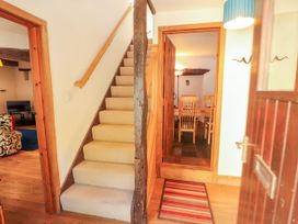 A hallway with stairs and a view into the dining area at Beck Edge in Braithwaite