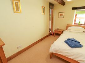A bedroom with a bed and side table at Beck Edge in Braithwaite