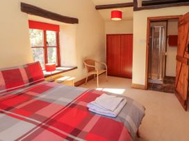 A bedroom with a bed, chair, and shower at Beck Edge in Braithwaite